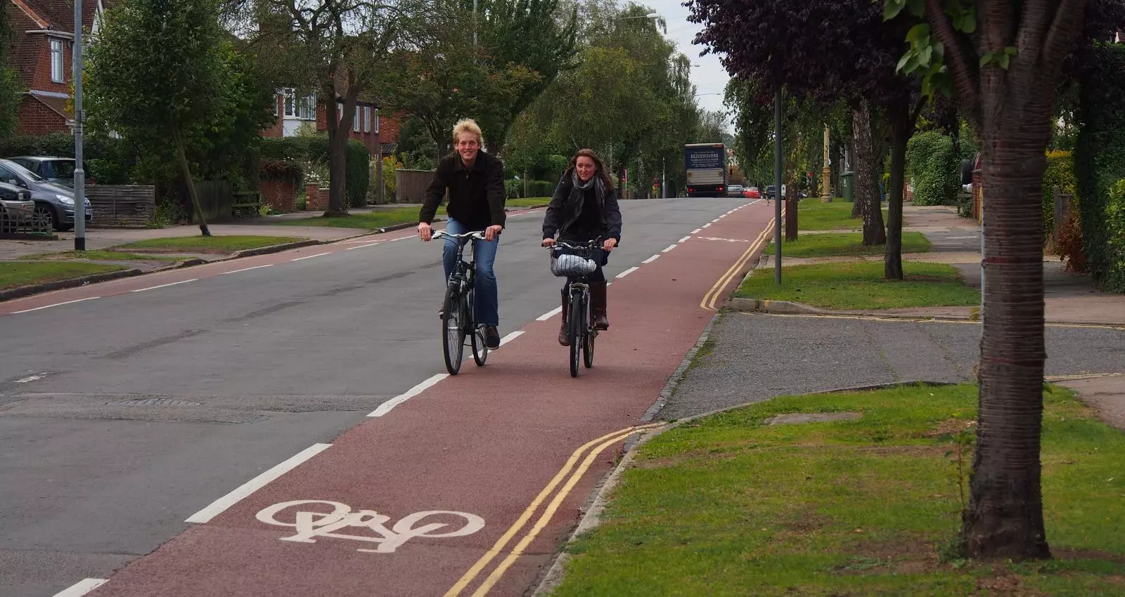 Photo of a road showing much wider advisory cycle lanes, and centre lines removed. This illustrates an alternative road layout that slows traffic rather than makes it feel safer to go fast.